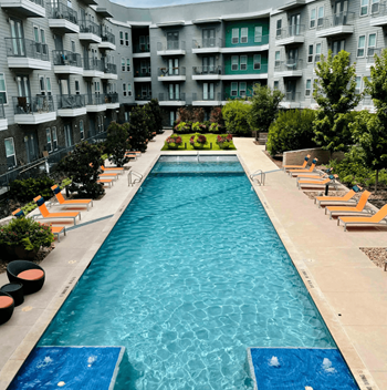 Large Swimming Pool with In-Water Fountain Aspect and Chairs at Abstract at Design District in Dallas, TX