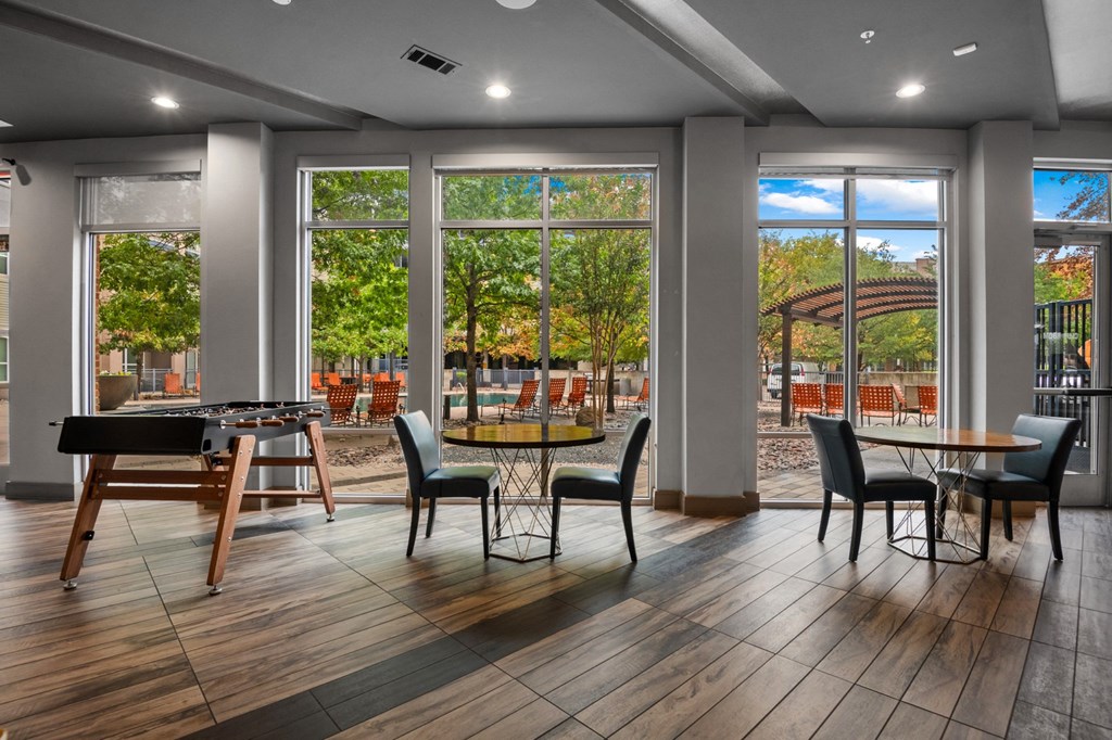 a clubhouse with tables and chairs and large windows at South Side Flats, Dallas, 75215