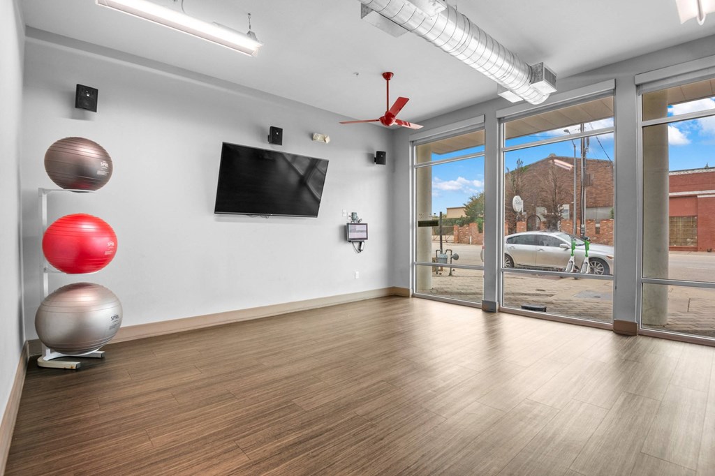 the living room of a house with a tv and a door to a parking lot at South Side Flats, Texas, 75215
