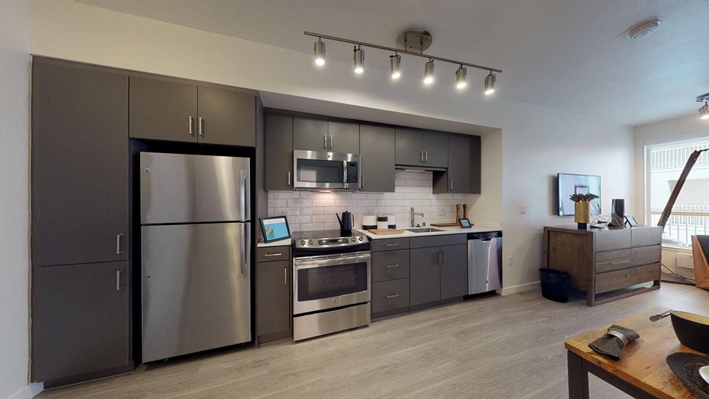 a kitchen with stainless steel appliances and gray cabinets