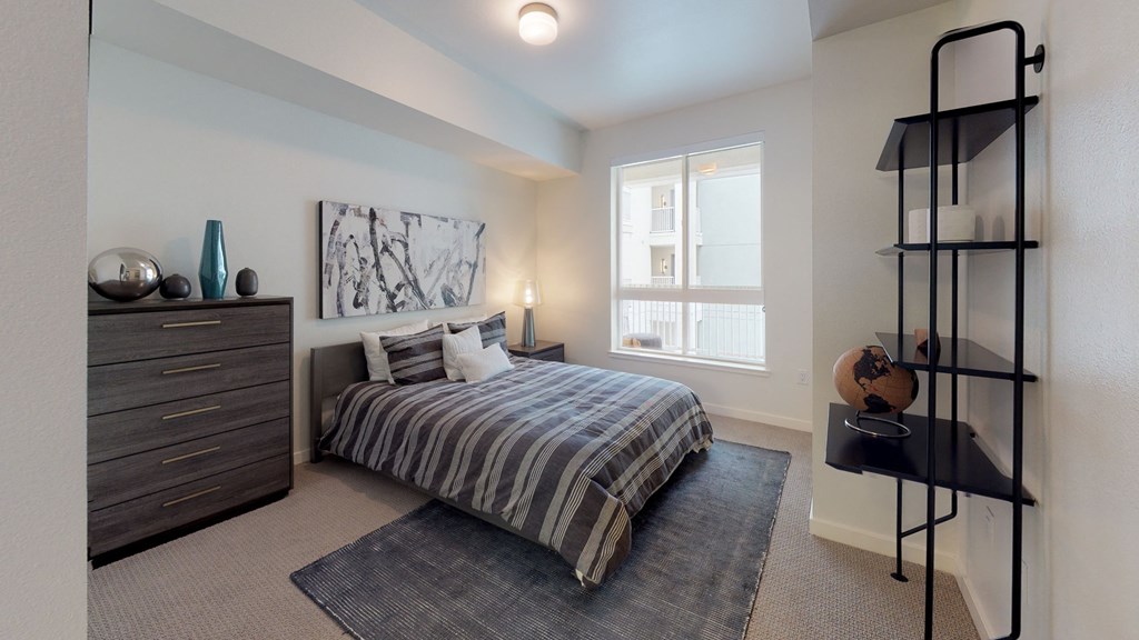 a bedroom with a bed and a dresser and a window