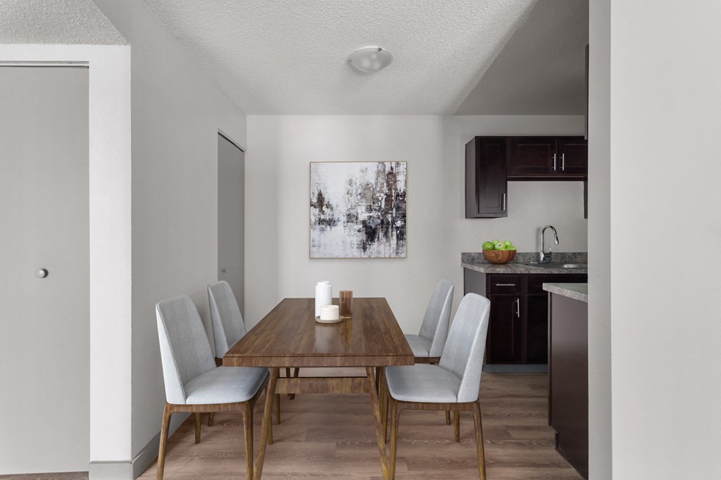 a dining room with a wooden table and chairs and a kitchen  at Verona, Littleton, CO, 80123