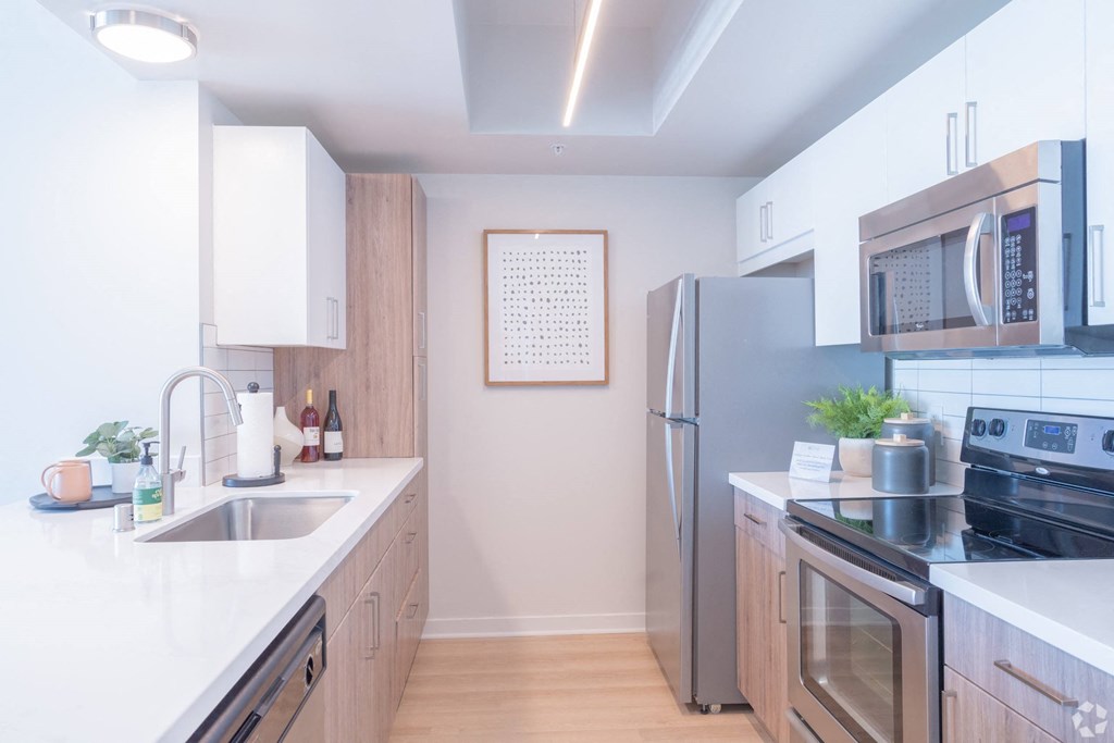 a kitchen with stainless steel appliances and white counter tops at Vue, San Pedro, CA 90731