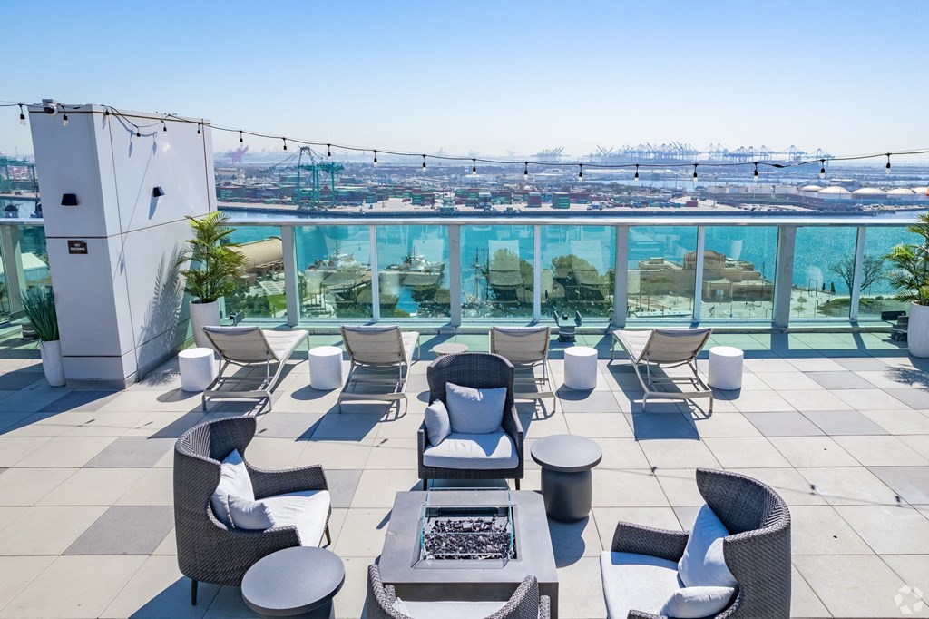 a rooftop patio with chairs and tables and a view of the city at Vue, San Pedro, CA 90731