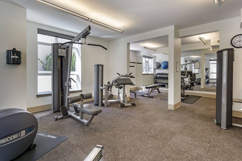 a spacious fitness center with exercise equipment and windows  at 128 on State, Kirkland