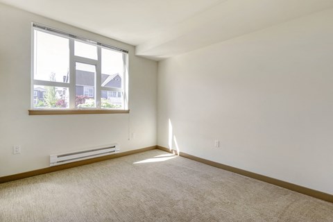 a bedroom with a large window and plush carpet at 128 on State, Kirkland, Washington