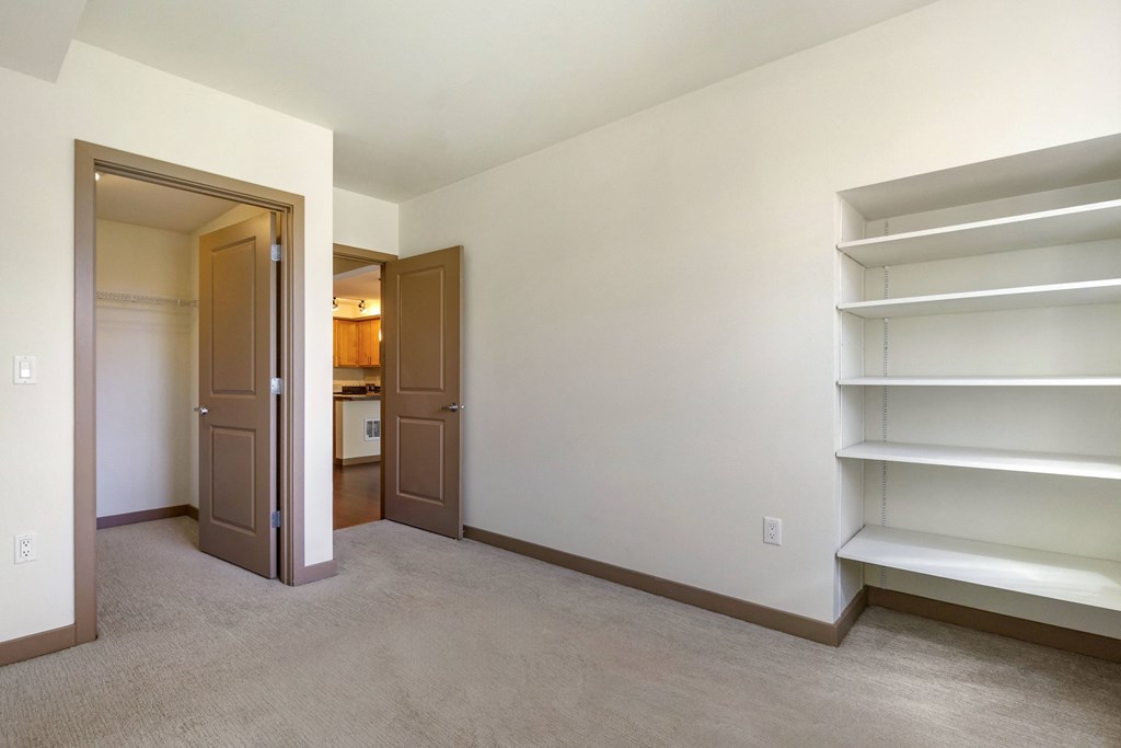 a bedroom with white walls and built in white shelves at 128 on State, Washington, 98033