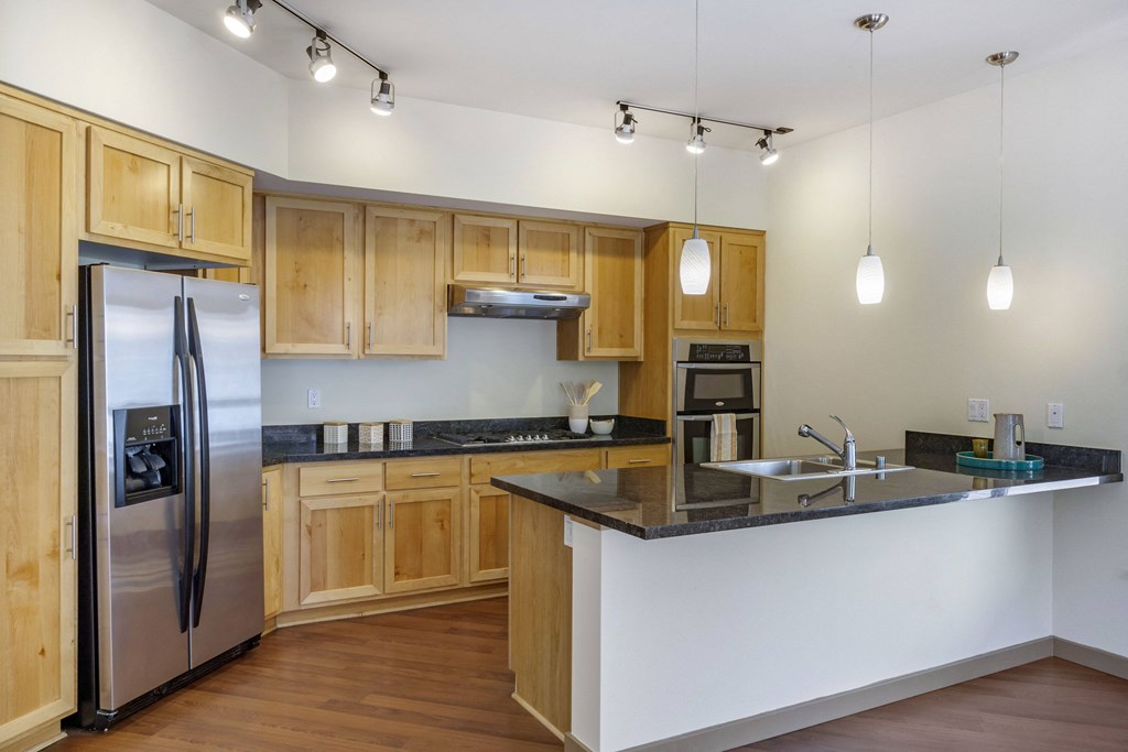 a kitchen with a large island, elegant cabinetry, and stainless steel appliances  at 128 on State, Washington