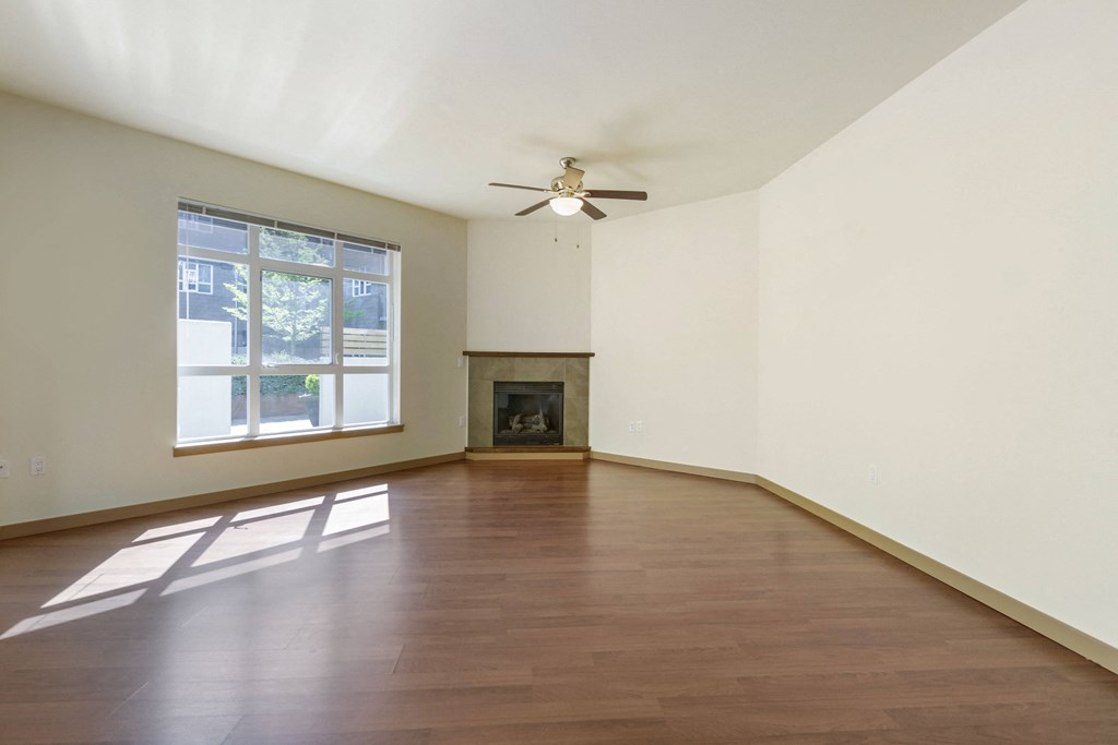 an oversized living room with plank flooring, a fireplace, and a ceiling fan at 128 on State, Washington