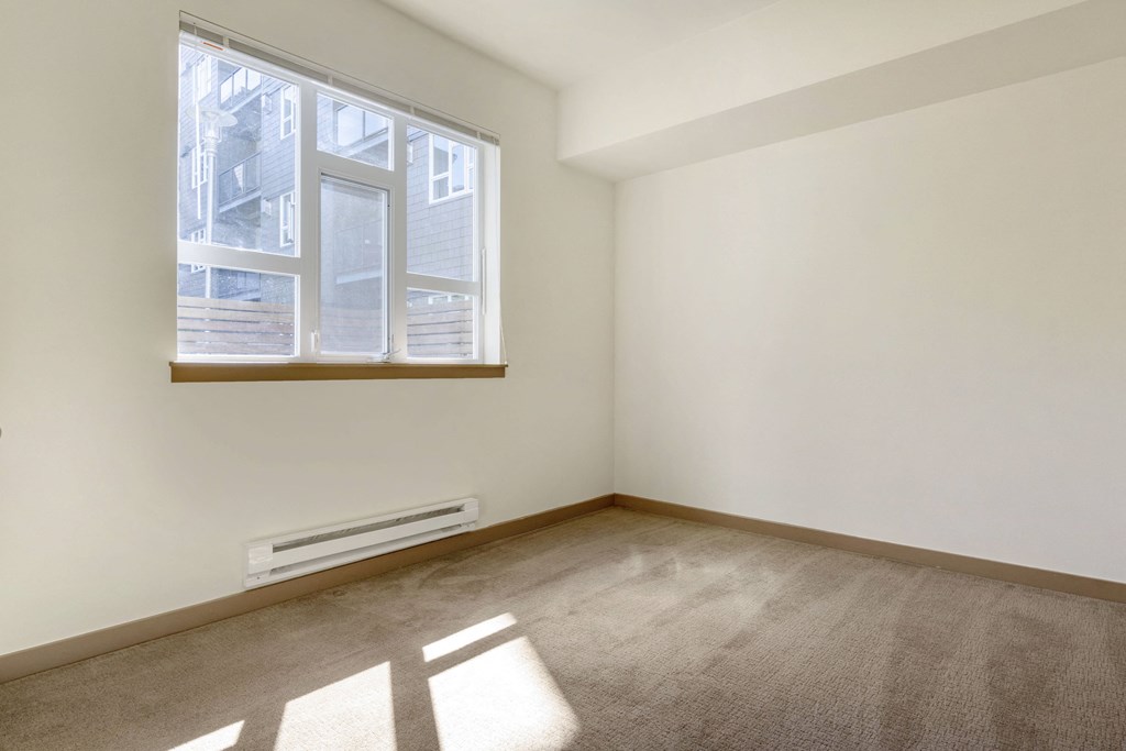 a bedroom with a large window and a carpeted floor  at 128 on State, Washington