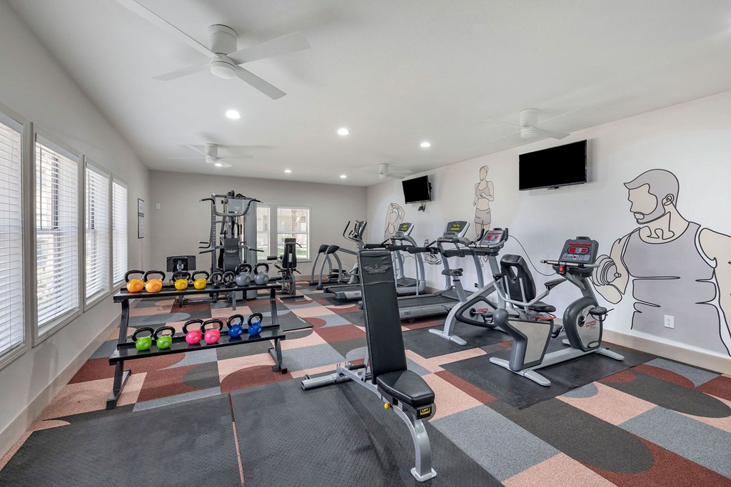 a home gym with exercise equipment and a wall mural of a man on the wall at Paisley and Pointe Apartments, Las Vegas, NV