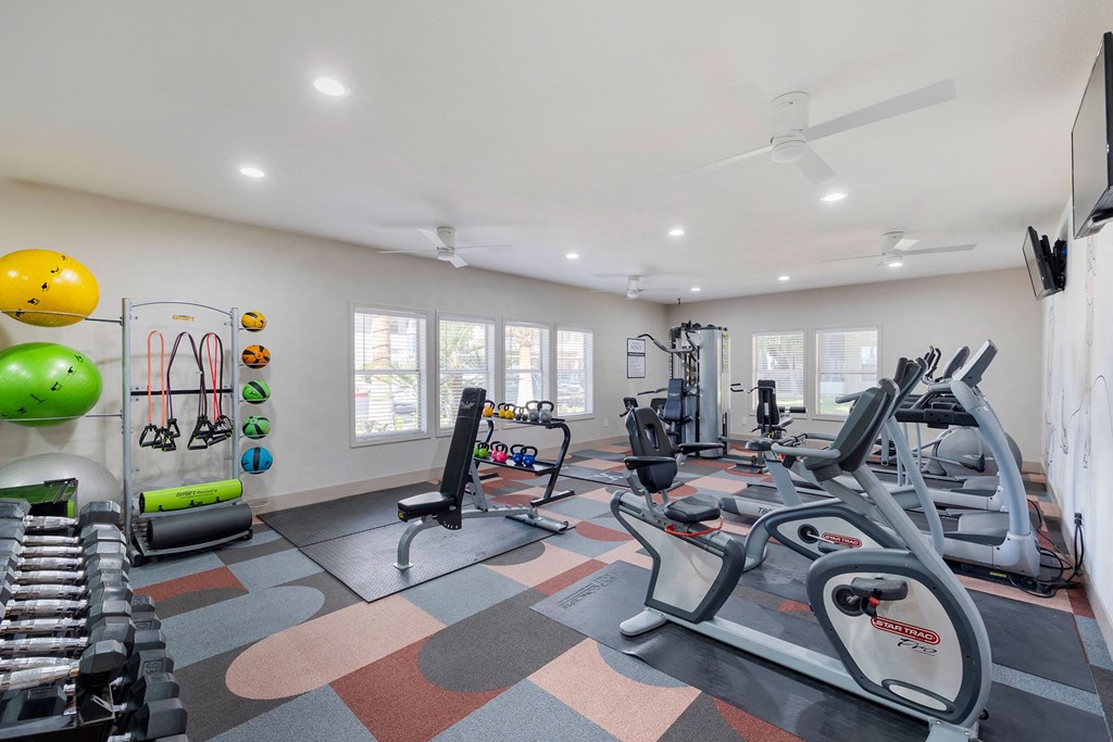 a gym with treadmills and other exercise equipment and windows at Paisley and Pointe Apartments, Las Vegas, 89130