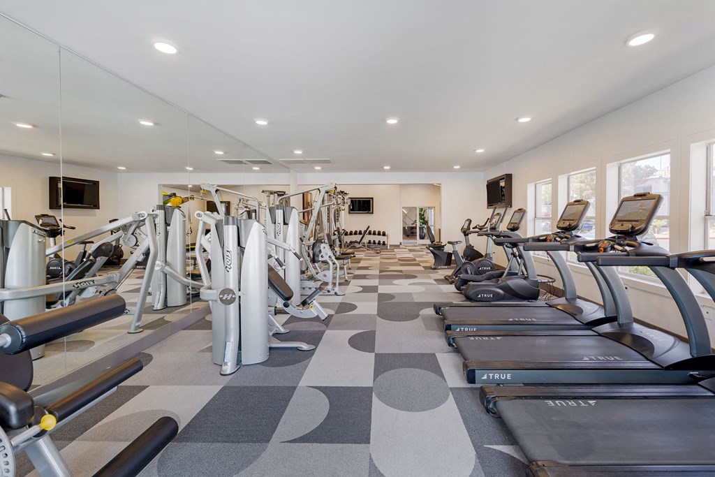 a gym with cardio equipment and weights on a checkered floor at Paisley and Pointe Apartments, Las Vegas, Nevada