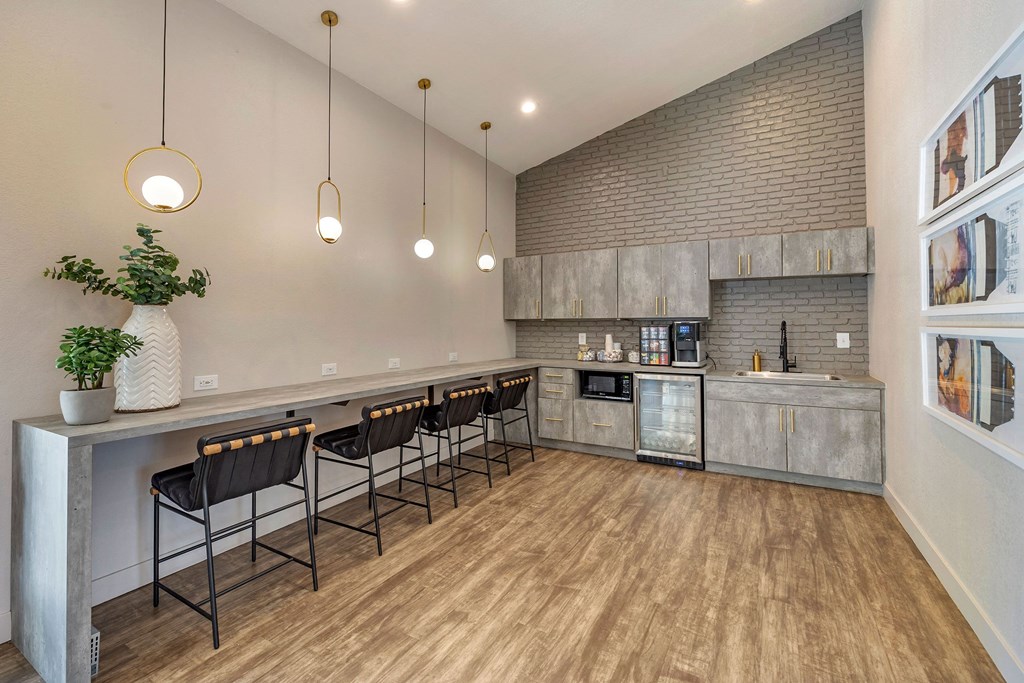 a kitchen with a bar and chairs in front of a counter at Paisley and Pointe Apartments, Las Vegas, Nevada