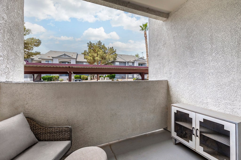 a balcony with a couch and a chair and a fireplace at Paisley and Pointe Apartments, Las Vegas, Nevada