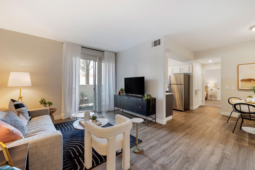 a living room with a couch and a tv at Paisley and Pointe Apartments, Las Vegas