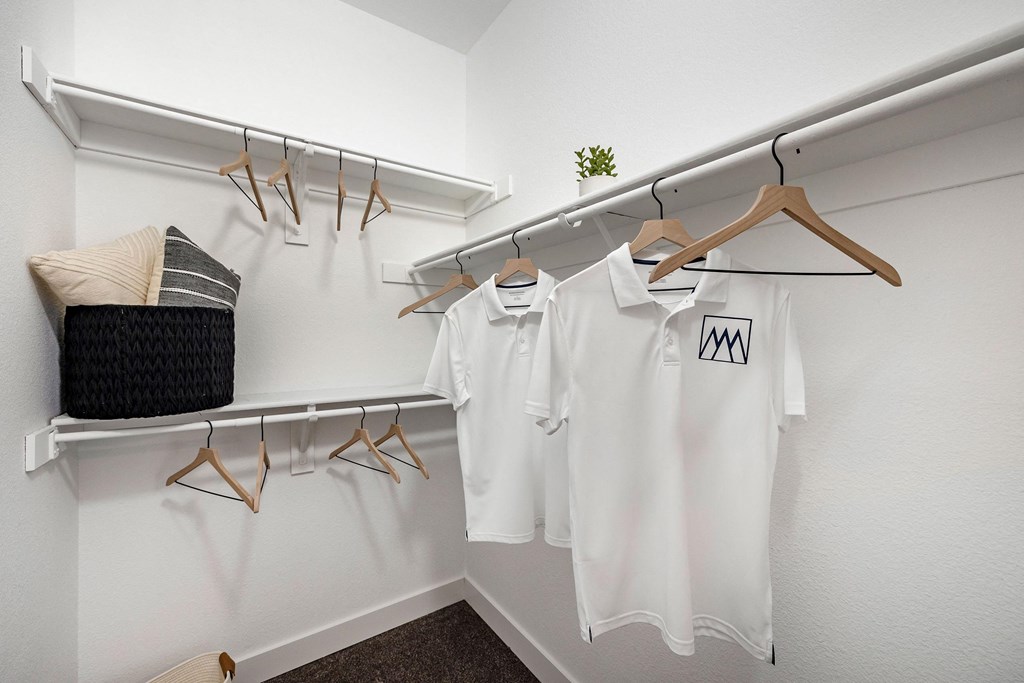 white shirts hanging on a rack in a dressing room at Paisley and Pointe Apartments, Nevada