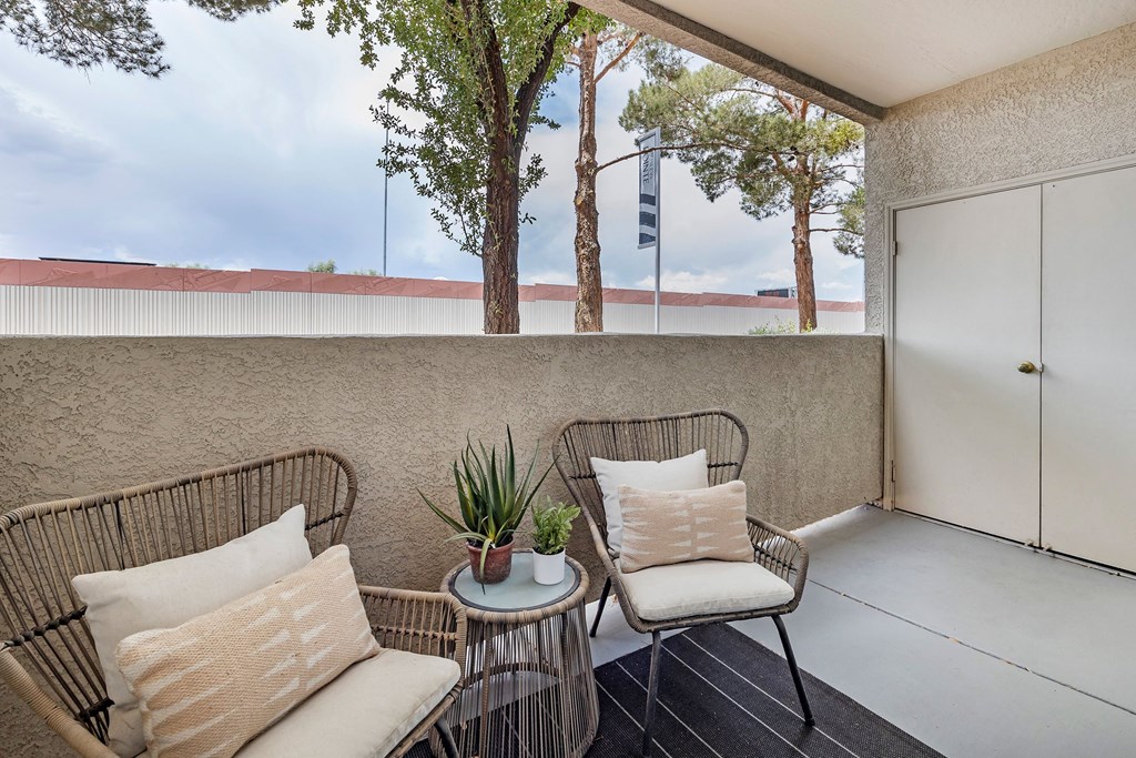a balcony with two chairs and a table at Paisley and Pointe Apartments, Las Vegas, NV 89130