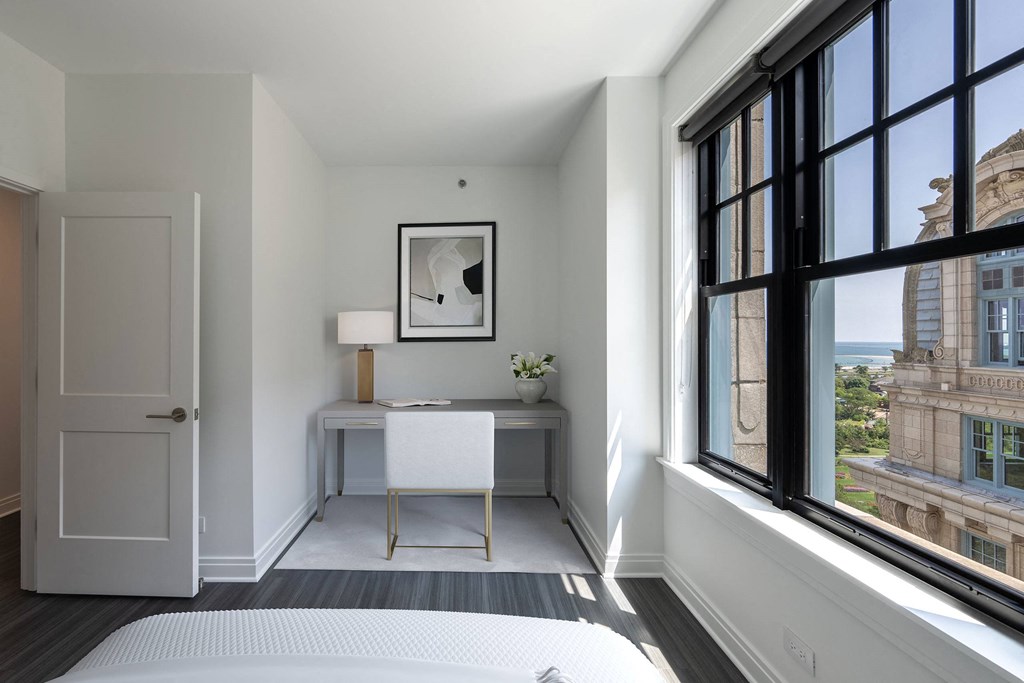 a bedroom with a bed and a desk and large windows  at The Belden Stratford, Chicago, 60614