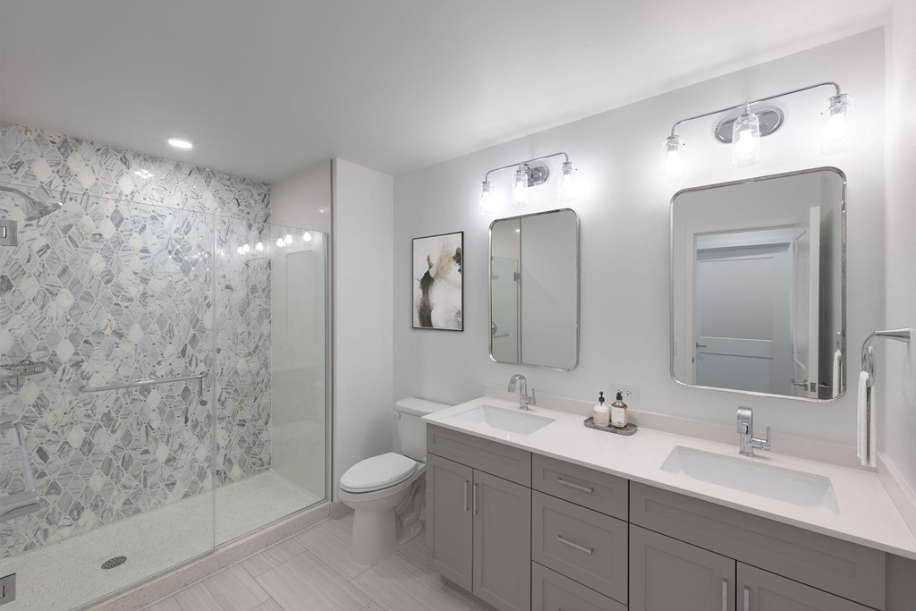 a white bathroom with two sinks and a shower  at The Belden Stratford, Chicago, IL