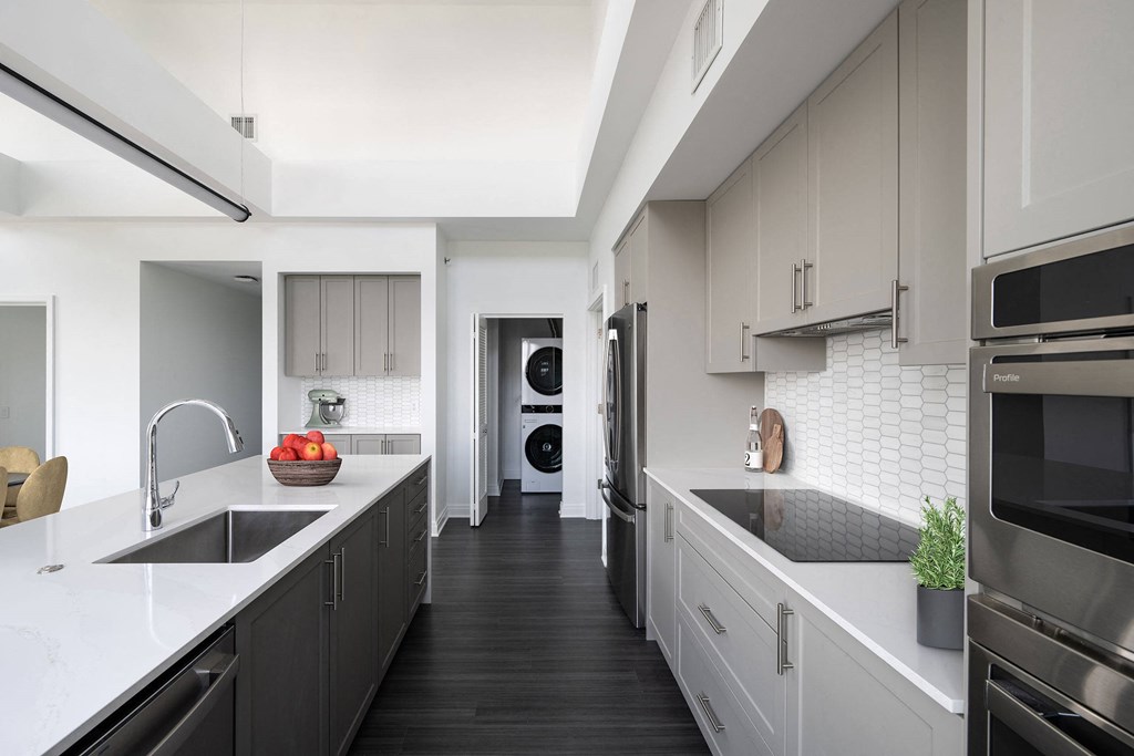 a large kitchen with white counter tops and black appliances  at The Belden Stratford, Chicago, 60614
