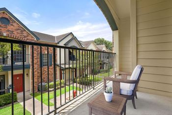 a patio with a chair and a table on a balcony at Aston at Cinco Ranch in Katy, Texas