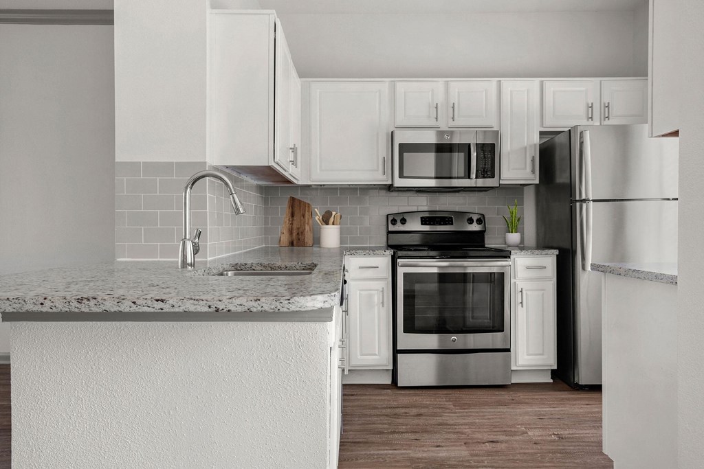 a kitchen with white cabinets and stainless steel appliances
