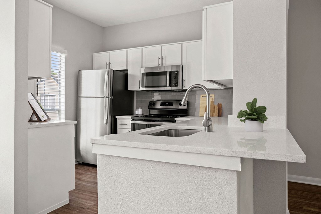 an empty kitchen with a sink and a refrigerator at Aston at Cinco Ranch, Katy, Texas