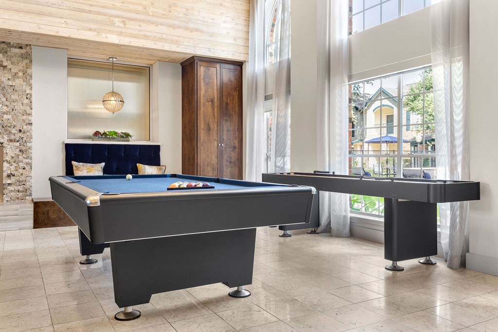 two pool tables in a living room with large windows at Aston at Cinco Ranch, Katy, 77450