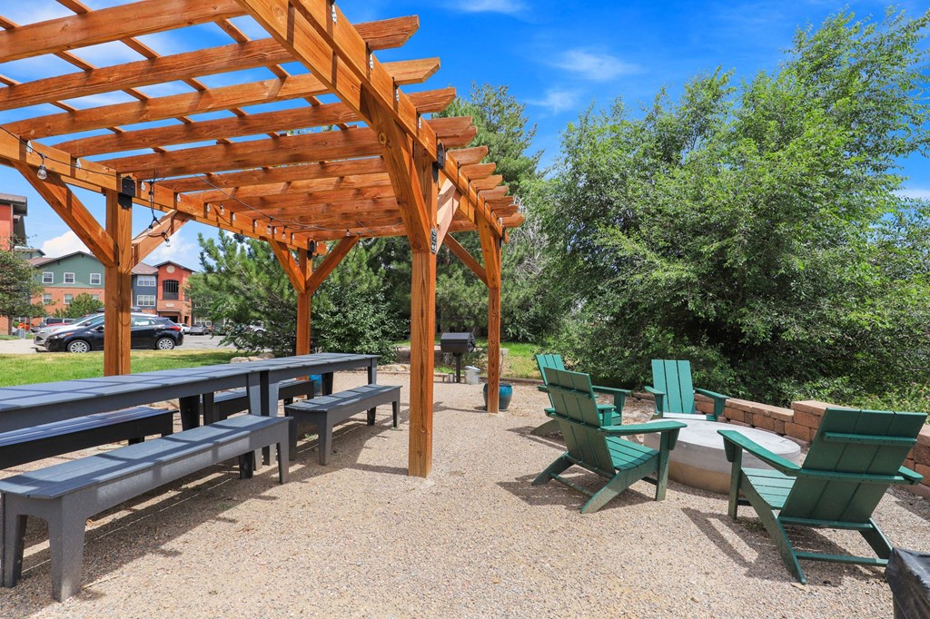 a picnic area with benches and tables and a pergola at Switchback on Platte Apartments, Colorado