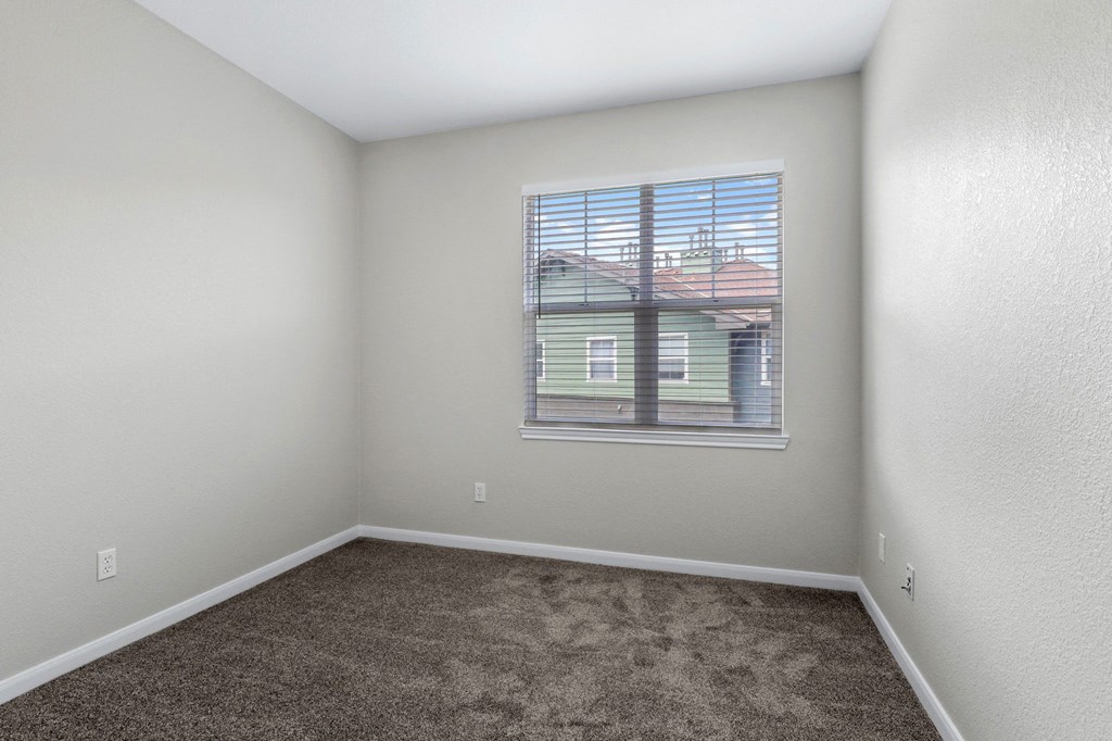 an empty room with carpet and a window  at Switchback on Platte Apartments, Littleton, CO 80120