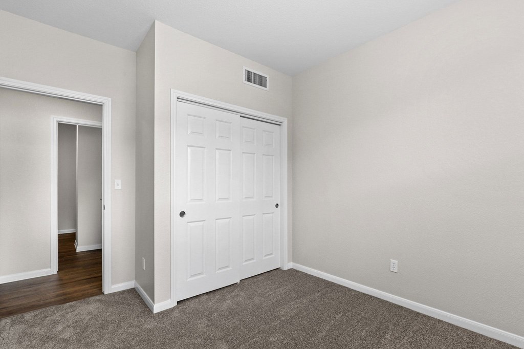 a bedroom with a white door and a door to a closet at Switchback on Platte Apartments, Littleton, 80120