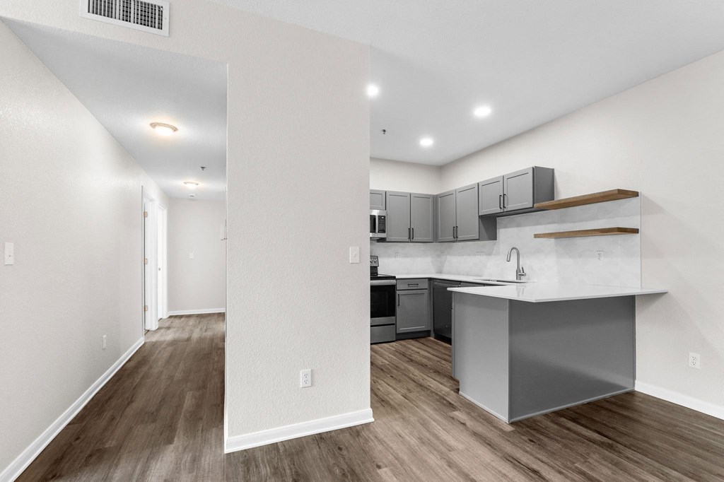 the living room and kitchen of a new home with an open floor plan at Switchback on Platte Apartments, Colorado