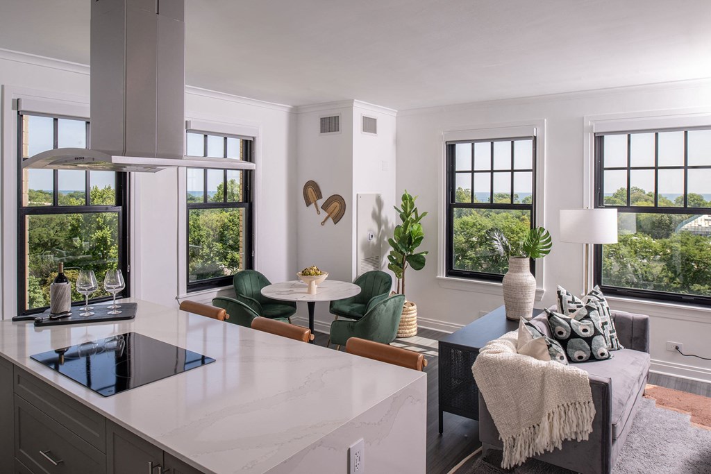 a kitchen with a white counter top and a living room  at The Belden Stratford, Chicago, Illinois