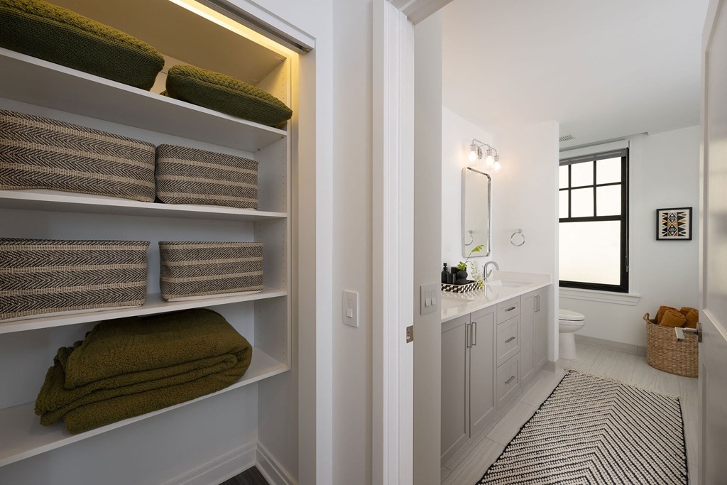 a bathroom with a sink and shelves with towels  at The Belden Stratford, Chicago, 60614