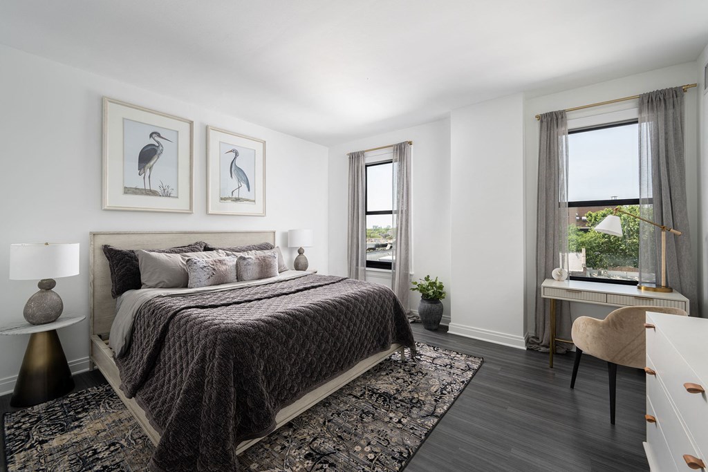 a bedroom with a bed and two windows  at The Belden Stratford, Chicago, IL