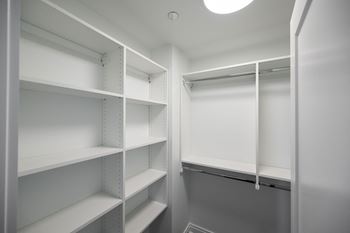 a walk in closet with white shelving and a light in it  at The Belden Stratford, Illinois, 60614