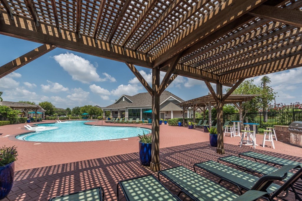 a large swimming pool with lounge chairs and a wooden pavilion at Sladestone Shadow Creek, Pearland, TX, 77584