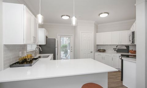an open kitchen with white counters and white cabinets and a white counter top at Sladestone Shadow Creek, Texas, 77584