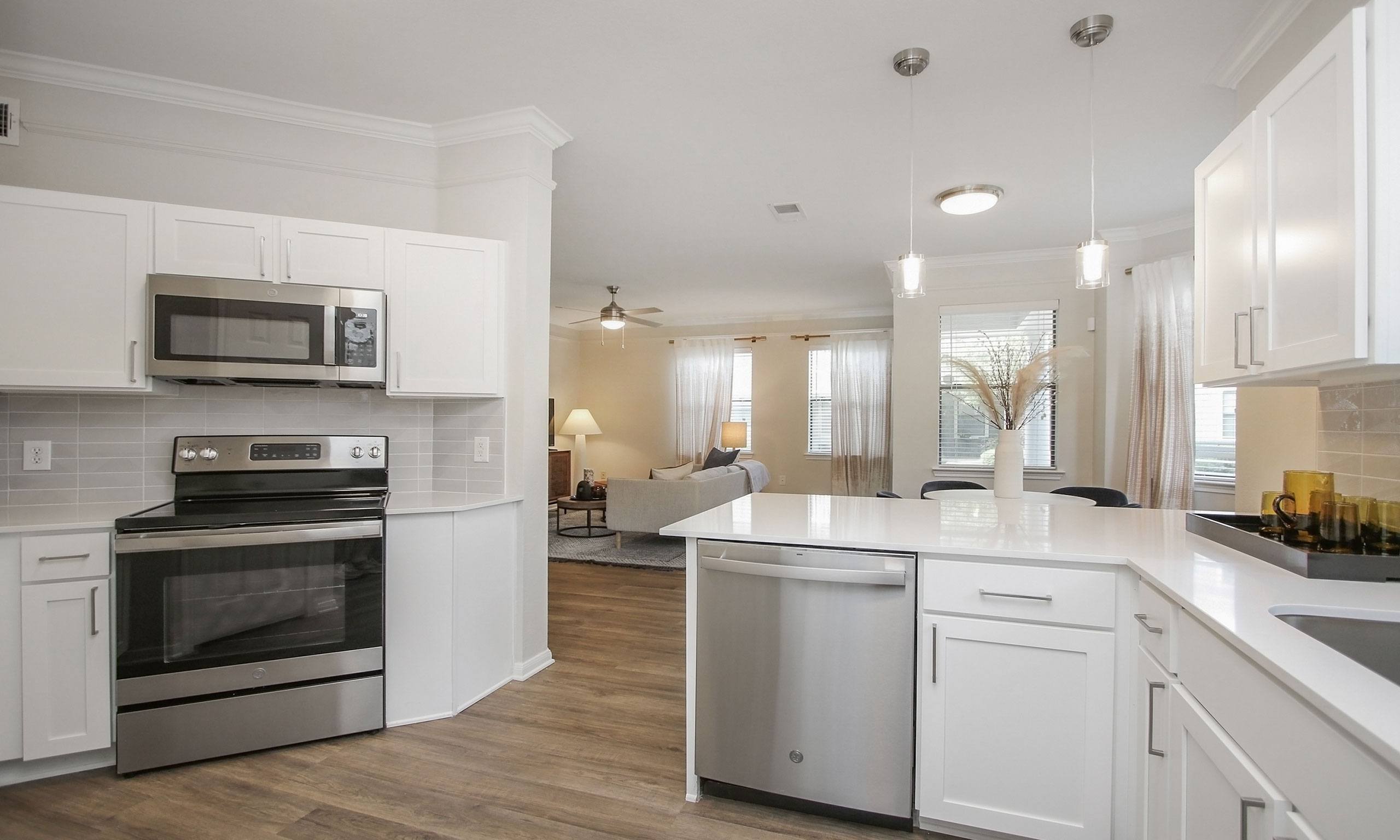 a kitchen with white cabinets and stainless steel appliances at Sladestone Shadow Creek, Pearland