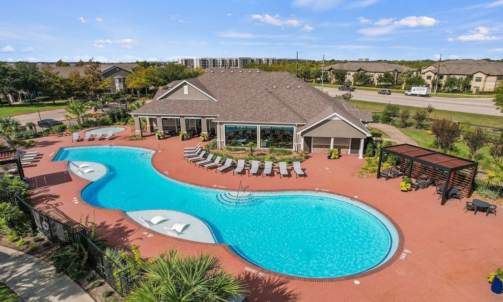 an aerial view of a swimming pool and a house with a resort style pool at Sladestone Shadow Creek, Texas