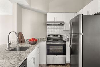 a kitchen with stainless steel appliances and granite counter tops at Arcadia Apartments, Centennial, 80112