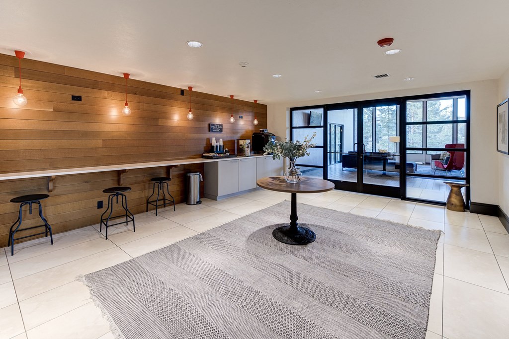 a living room with a bar and a kitchen with glass doors at Ashford Belmar Apartments, Lakewood