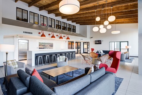a living room with couches and chairs and a kitchen at Ashford Belmar Apartments, Lakewood, CO