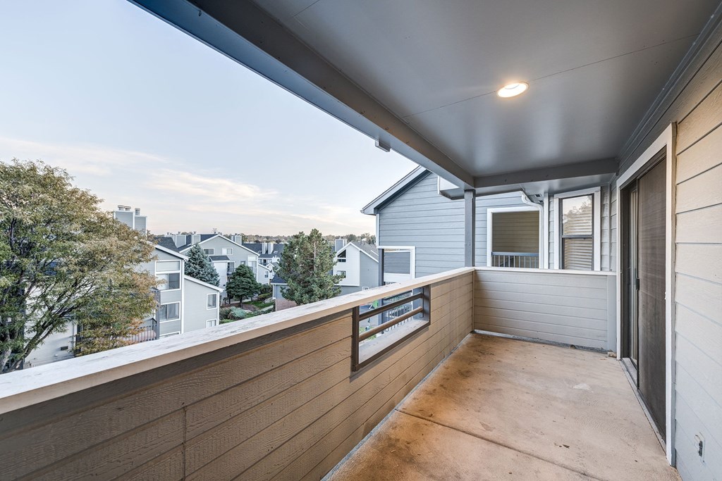 a balcony with a wood floor and a view of a city at Ashford Belmar Apartments, Lakewood, 80226