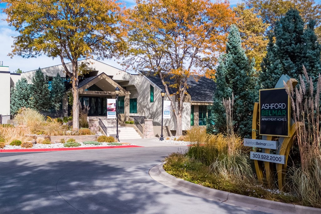 the front of a building with a street sign in front of it at Ashford Belmar Apartments, Lakewood, CO 80226
