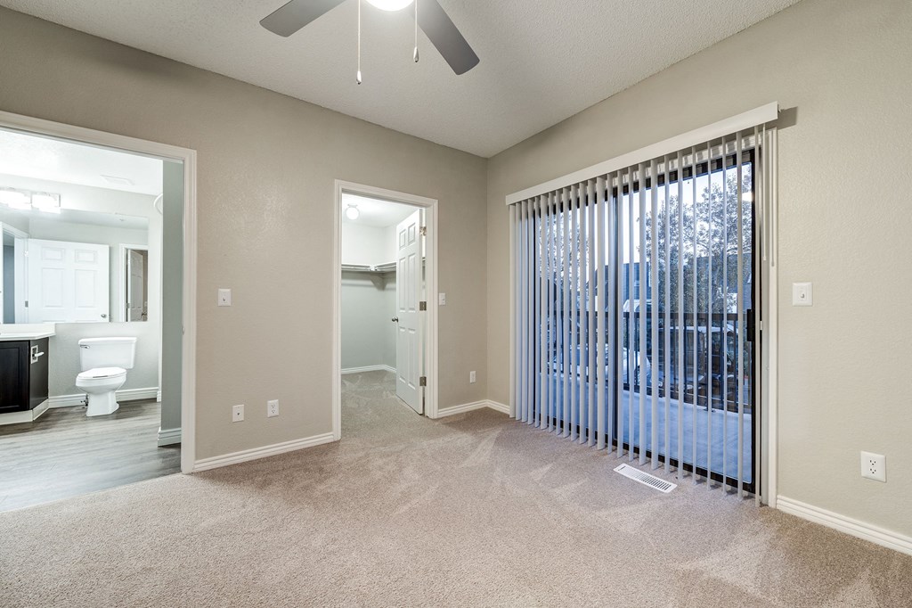 an empty living room with a large window and a ceiling fan at Ashford Belmar Apartments, Lakewood, CO