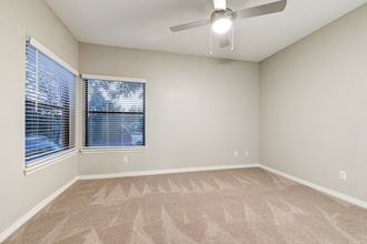 an empty living room with a large window and a ceiling fan at Apartments at Denver Place, Denver, 80202