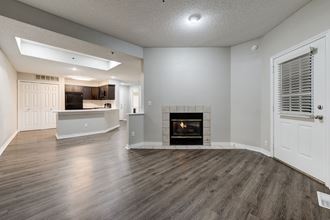 an empty living room with a fireplace and a kitchen at Apartments at Denver Place, Denver Colorado