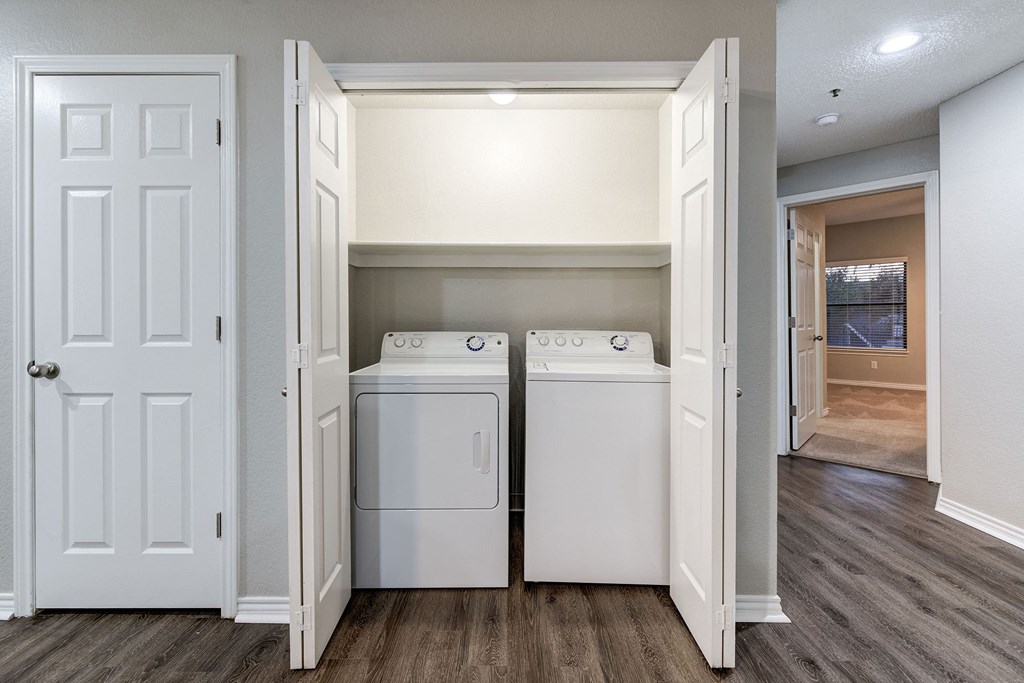 an empty laundry room with two washes and a dryer at Ashford Belmar Apartments, Lakewood, CO